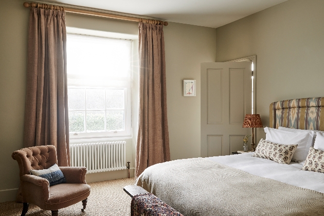 bedroom with cream decor large bed and arm chair