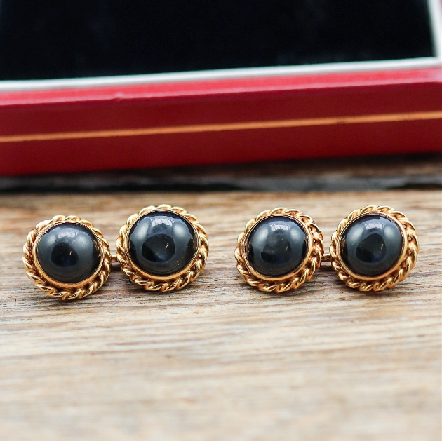 Two black and gold cufflinks